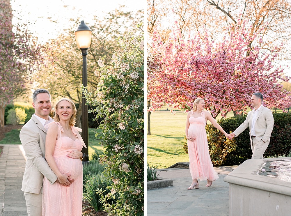 A pregnant woman wearing a pink dress embraces her husband during their Baker Park maternity photos in Frederick, Maryland.