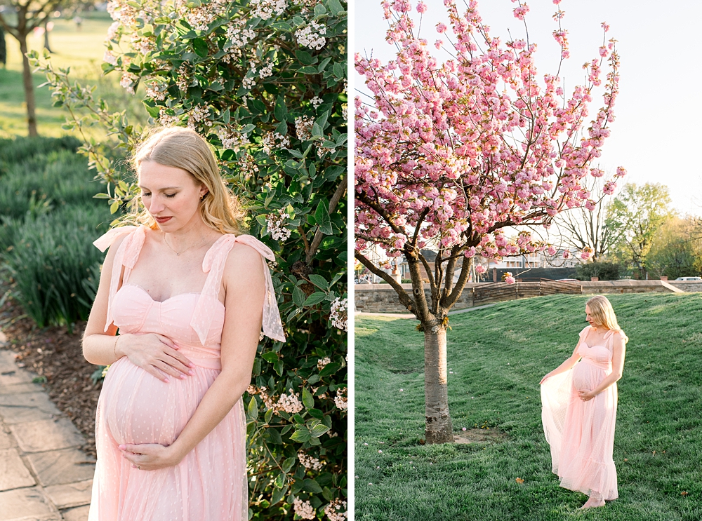 A pregnant woman wearing a pink dress holds her belly during her Baker Park maternity photos in Frederick, Maryland.