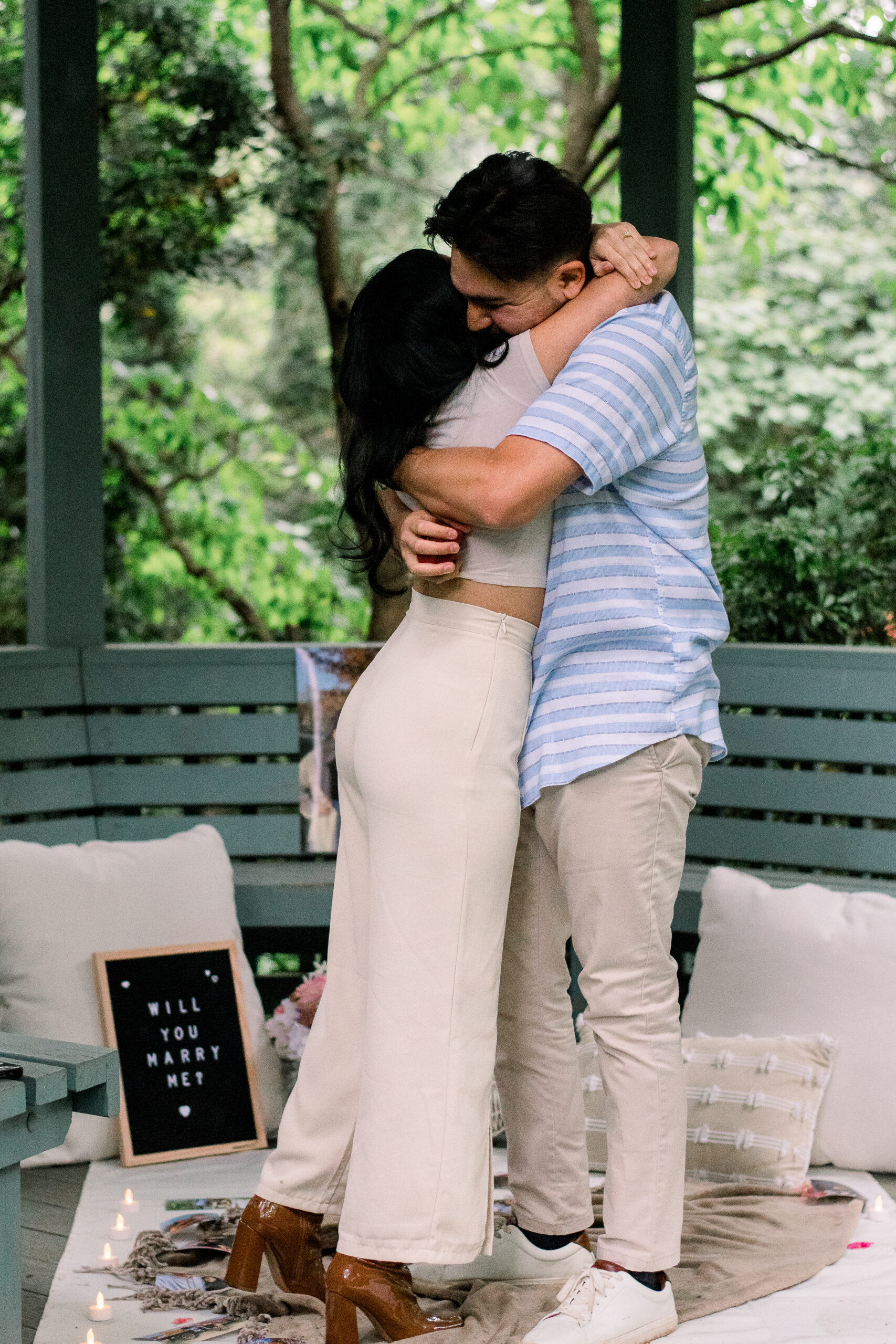 A recently engaged couple embraces after a surprise proposal at McCrillis Gardens in Bethesda, Maryland.